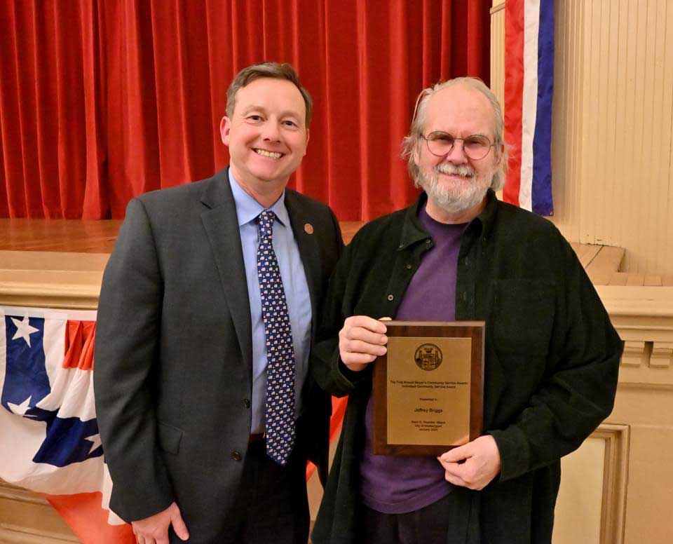 Sculptor Jeffrey Briggs receives a community service award from Mayor Sean Reardon